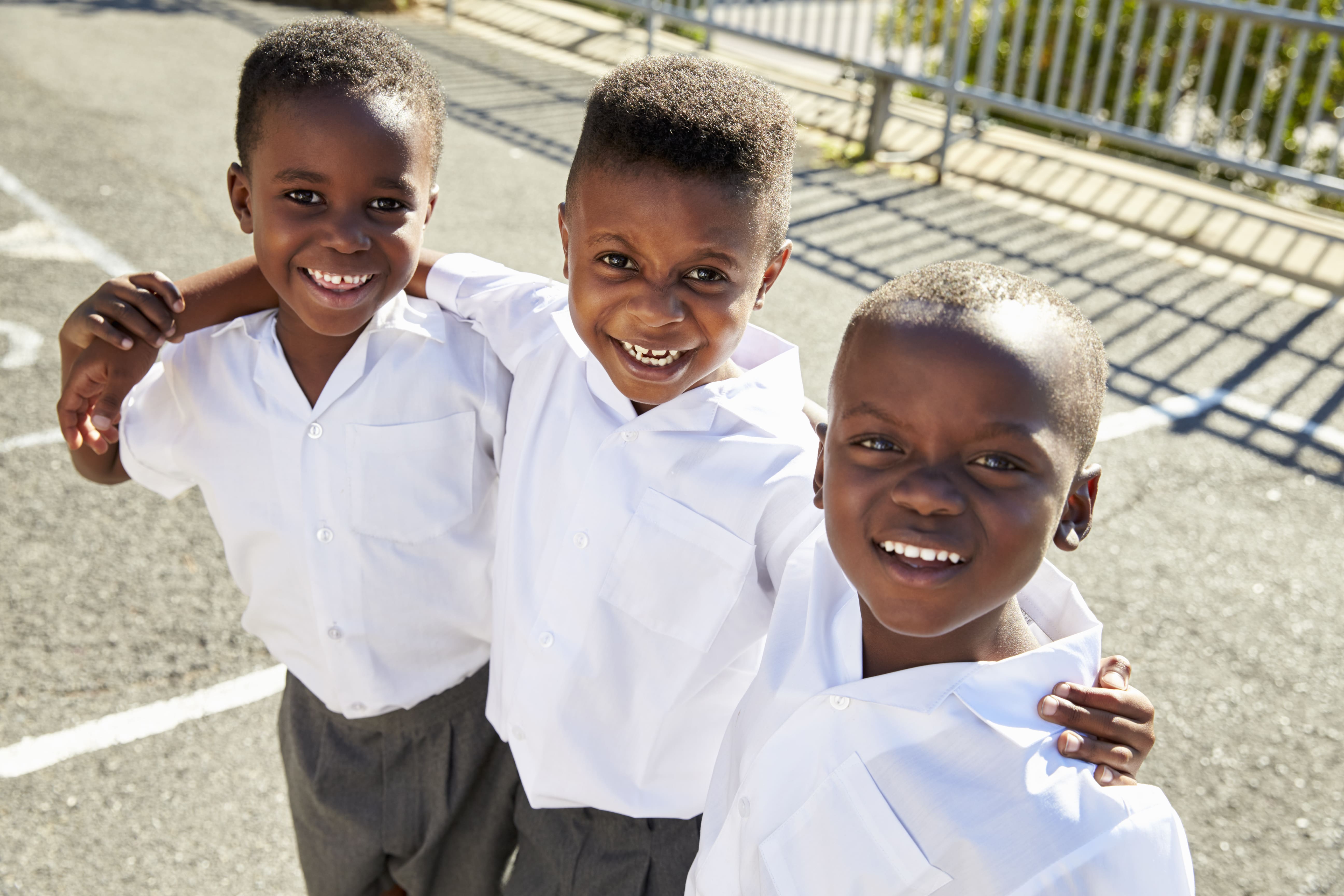 young-african-schoolboys-smiling-to-camera-in-a-PRTQHJ7-min
