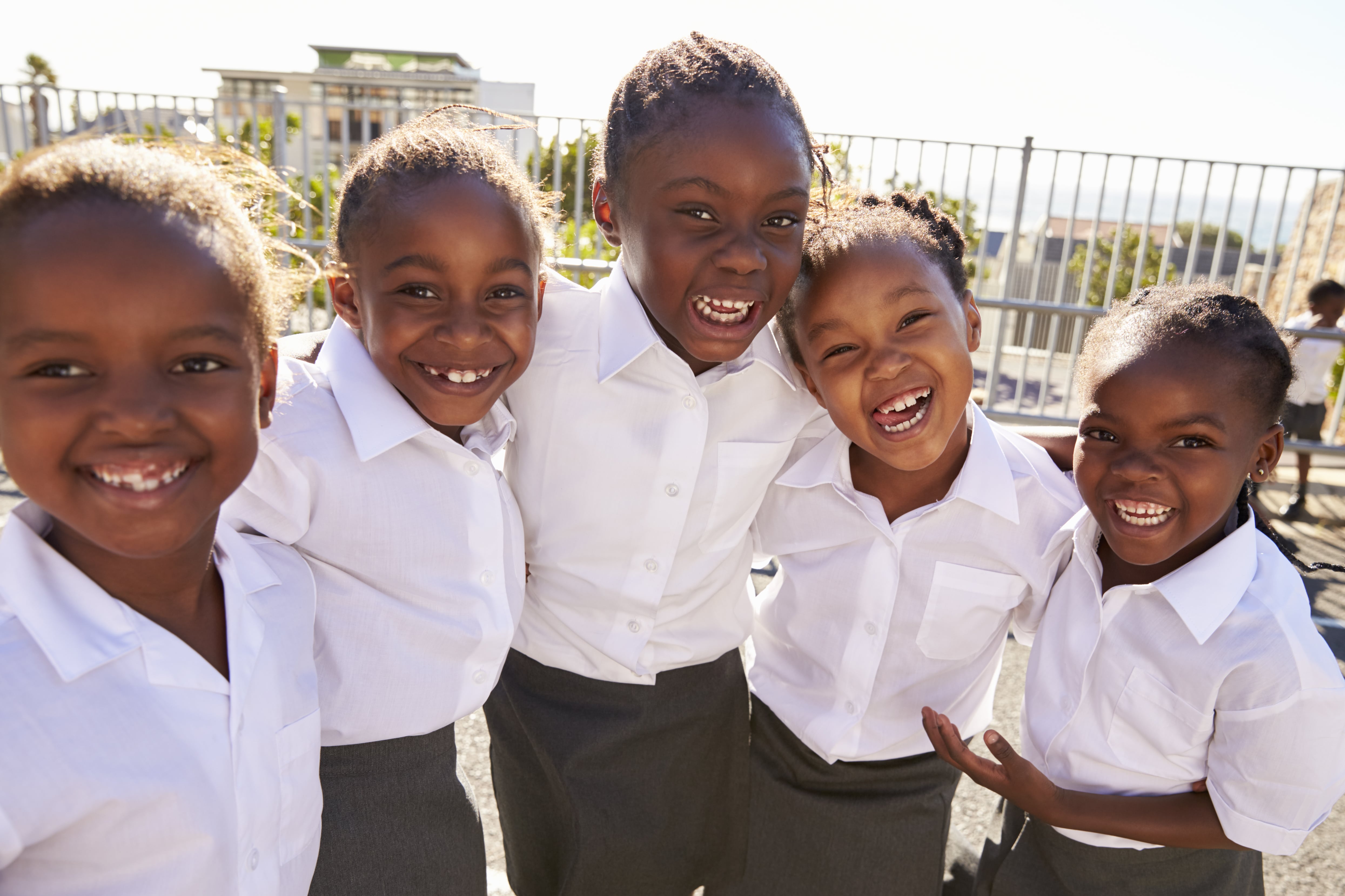 young-african-schoolgirls-in-playground-smiling-PTS5EQ7-min