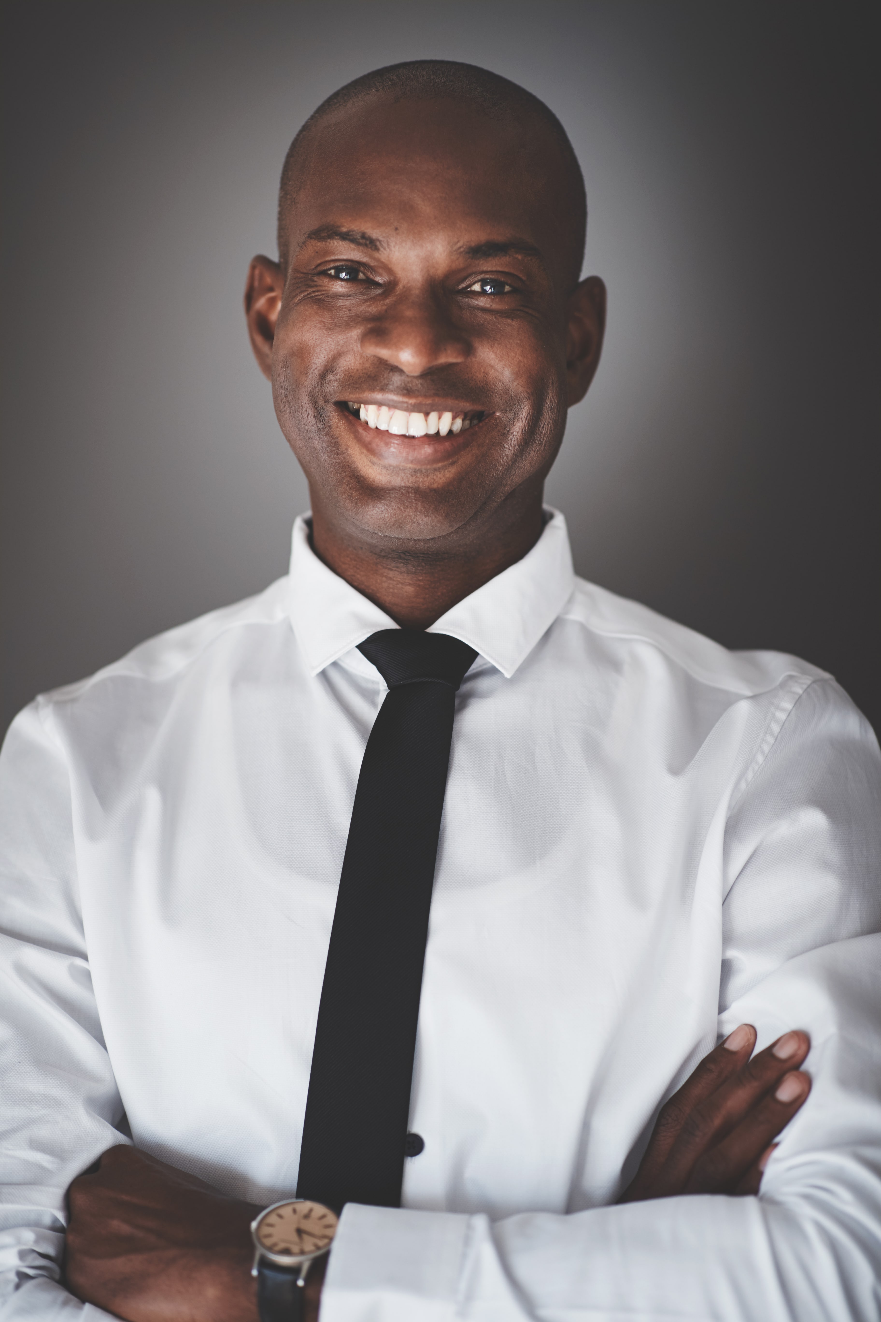 smiling-young-african-businessman-standing-5XQK2J9-min